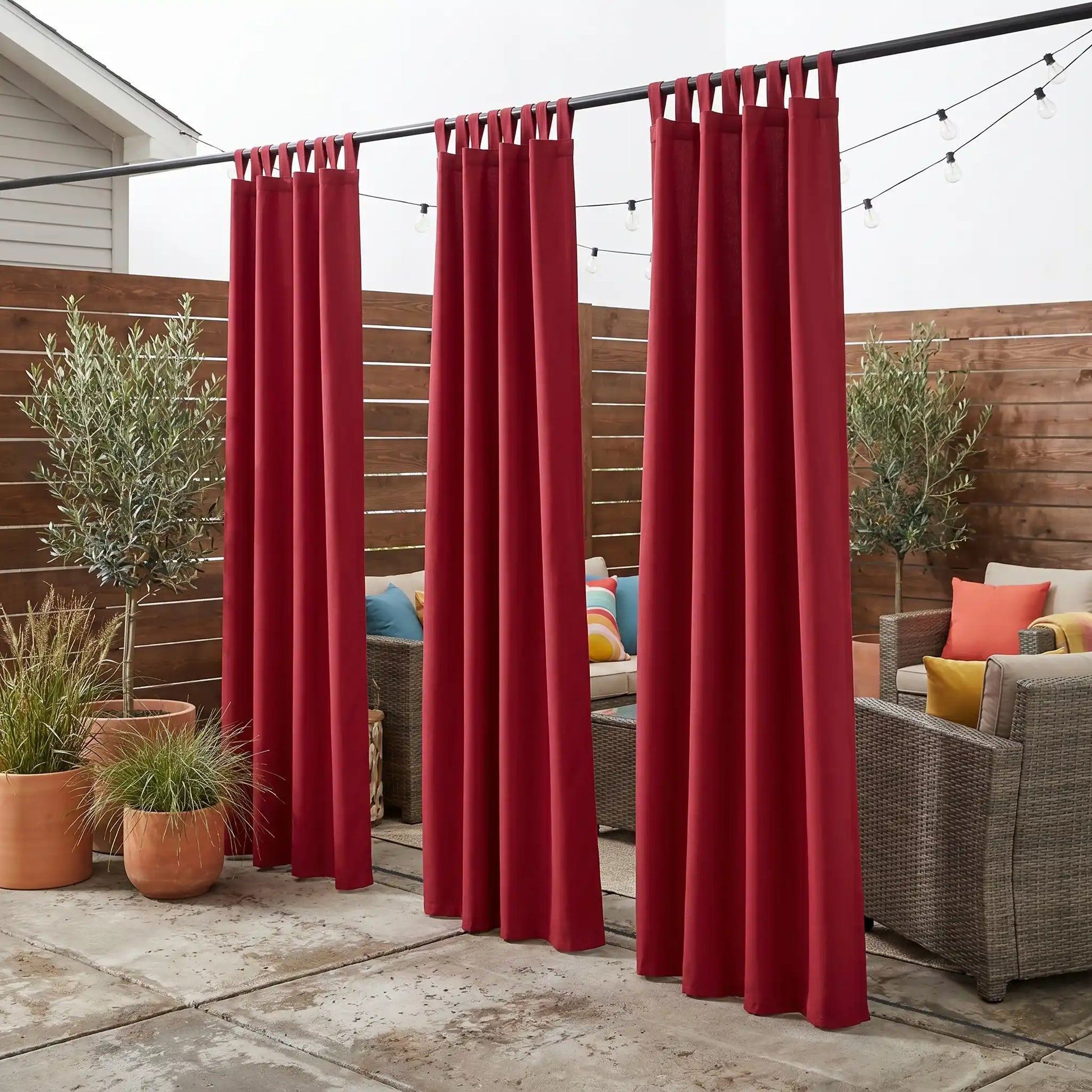 Outdoor waterproof windproof curtain with tab tops and ropes by DWCN Official, shown hanging outdoors in a natural setting.