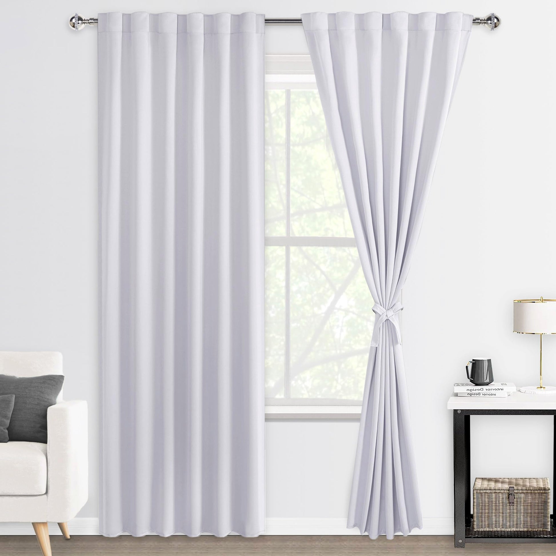 White curtains hanging in a living room with a window.
